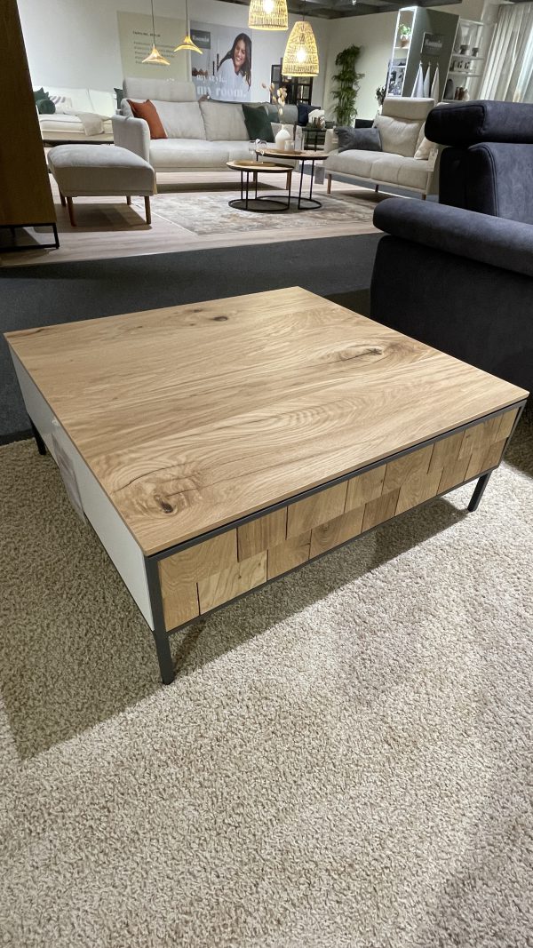 Couchtisch mit Metallbeinen auf einem beigen Teppich in einem modernen Wohnzimmer-Showroom.