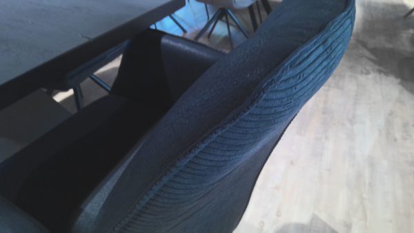 Der blau strukturierte Stuhl der Esstischgruppe Interliving 5116 steht neben einem dunklen Tisch auf einem hellen Holzfußboden, von oben gesehen.
