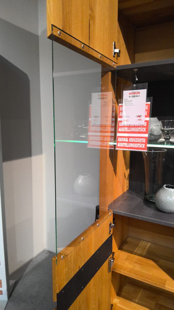 Der Schrank Anrichte Interliving-5603 verfügt über eine Glastür, die geöffnet werden kann und in der sich Glaswaren und Dekoration befinden.